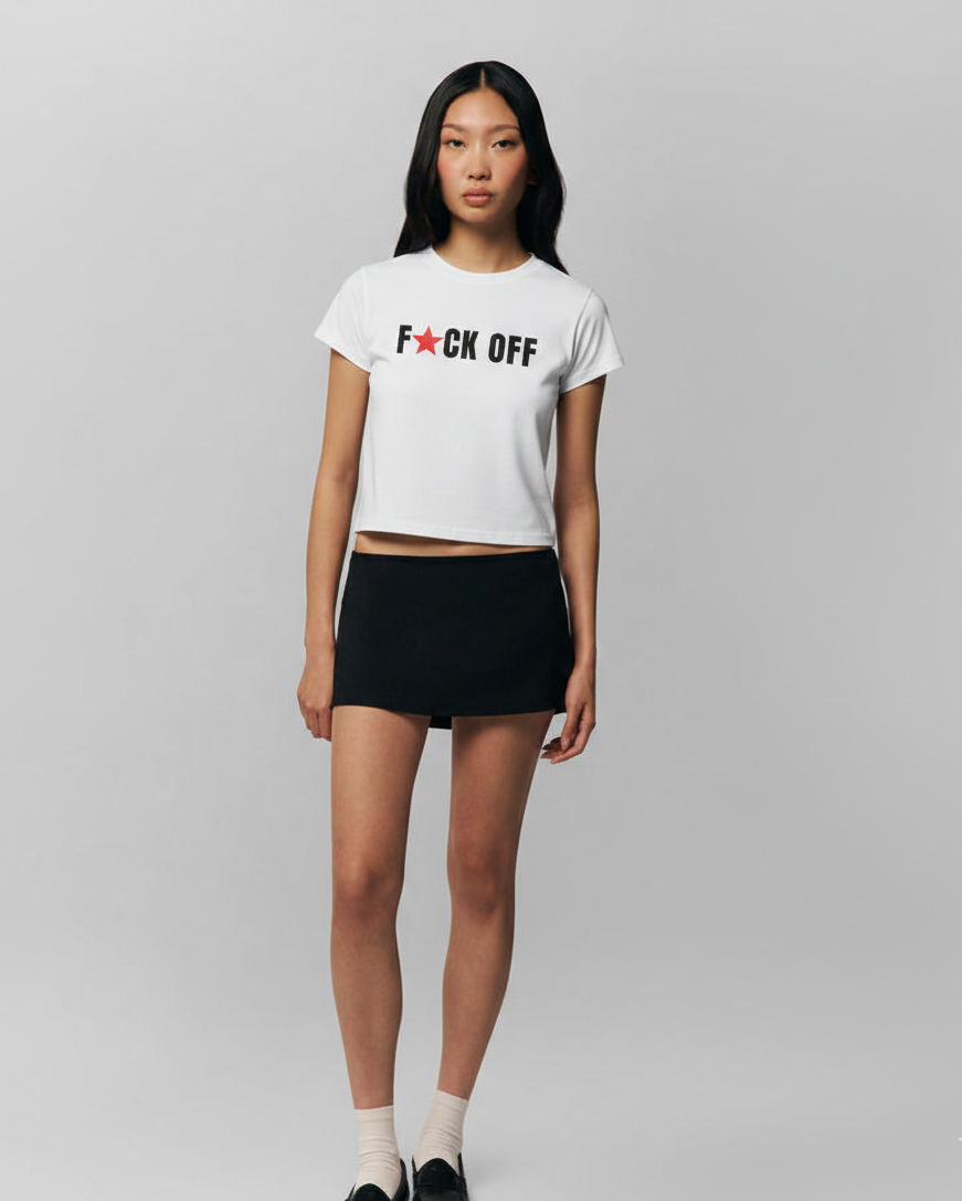 Person wearing a white t-shirt with text and a black skirt on a gray background