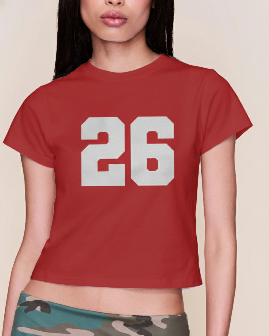 Red t-shirt with the number 26 worn by a person on a beige background