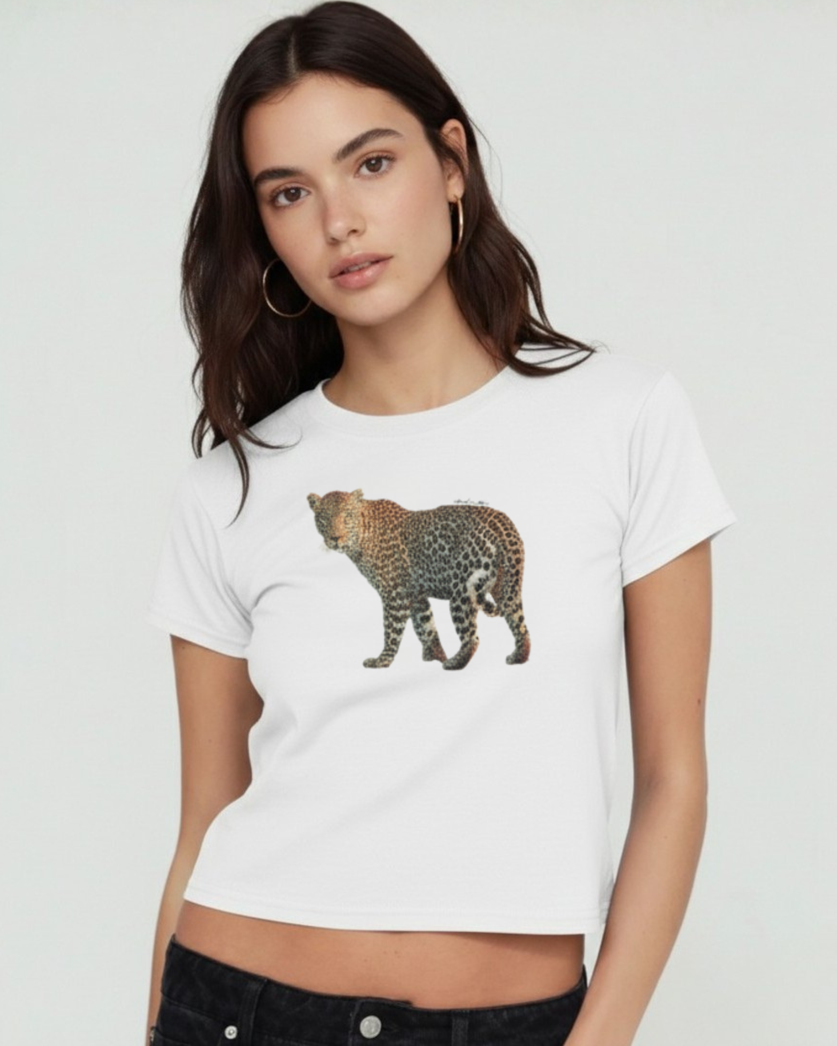 Woman wearing a white t-shirt with a leopard graphic on a plain background