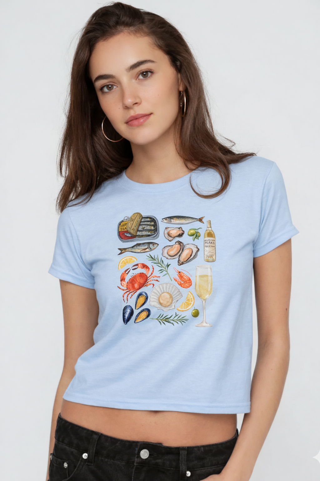 Woman wearing a light blue t-shirt with seafood illustrations on a plain background